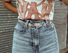 Simple silver belts are all the rage this season! Which means adding our Silver Concho Belt to your closet is a must. Wear with your favorite denim to make a statement all while showing off your western flair!   S/M is 42in end to end, but you can adjust the last 7-8in (Pendant 16pcs) L/XL is 45.5in end to end, but you can adjust the last 7-8in (Pendant 18pcs)  Model is wearing S/M. Silver Western Belt, Concho Belt Outfit, Western Belts Outfit, Country Belts, Belt Outfit, Cowgirl Aesthetic, Rodeo Outfits, Concho Belt, Cowgirl Chic