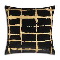 a black and gold pillow with squares on the front, in an abstract pattern design