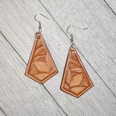 the earrings are made out of wood and have an intricate design on them, which makes it