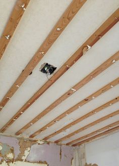 an unfinished room with wood beams and electrical wires attached to the ceiling that has been stripped off