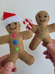 two handmade gingerbread men holding candy canes