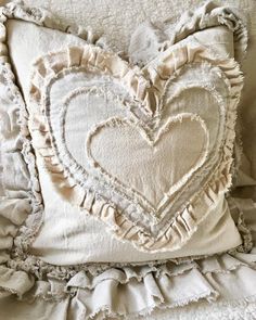 a white heart pillow with ruffled edges