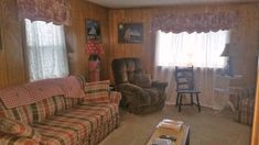 a living room filled with furniture and a window covered in curtains next to a coffee table