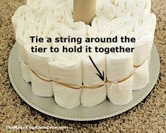 a cake made out of toilet paper on top of a silver platter with the words tie a string around the tier to hold it together