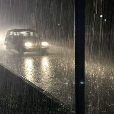 a car is driving through the rain at night