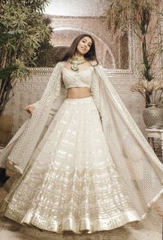 a woman in a white lehenga with long sleeves