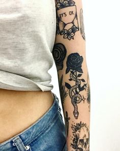 a woman's stomach with tattoos on her arm and the bottom half of her body