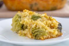 broccoli and rice casserole on a white plate with a muffin in the background