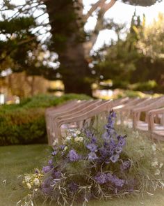 rows of chairs with purple flowers in the grass