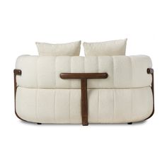 a white couch with two pillows on top of it and a wooden frame around the back