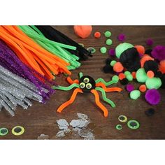 halloween decorations and crafts on a table with sprinkles, yarn, and plastic eyes