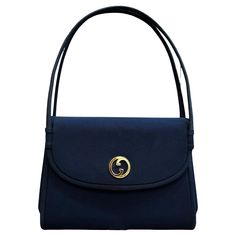 This vintage GUCCI small handbag is crafted of polyester fabric in navy featuring gold-toned hardware. Front flap magnatic snap closure opens to a navy satin interior featuring a patch pocket. This vintage Gucci is the perfect evening clutch for your night out essentials. Made in Italy. Measures approximately 8 x 6.5 x 1.5 inches. Comes with dust bag (slightly damaged) Condition - Very good vintage condition with minor signs of wear Outside: Very minor marks Inside: Minimal to no visible signs o Small Top Handle Bag, Gucci Handbag, Bags Gucci, Gucci Vintage, Vintage Clutch, Small Handbag, Vintage Bag, Evening Clutch, Gucci Handbags