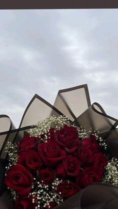 a bouquet of red roses with baby's breath