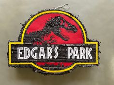 a sign that says edgar's park with a dinosaur on it