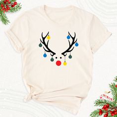 a t - shirt with reindeer's head and christmas balls on it