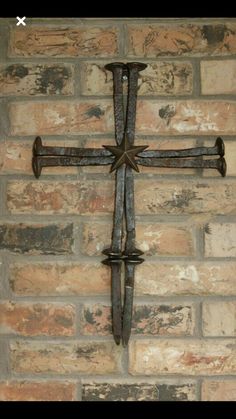 a metal cross mounted to the side of a brick wall