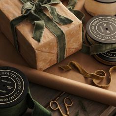 a wrapped present sitting on top of a wooden table next to scissors and other crafting supplies