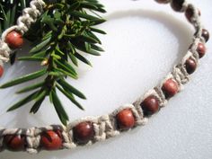 a close up of a bracelet made out of beads and wood beads on a white surface