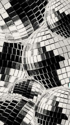 black and white photograph of disco balls in the middle of a dance floor with squares on them