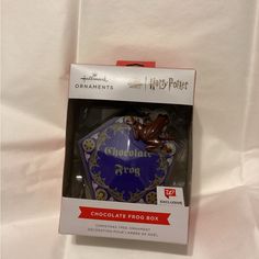 a harry potter ornament in its box on a white sheeted surface,