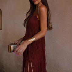 a woman in a red dress holding a gold purse