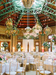 the inside of a building with chandeliers and tables set up for an event