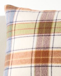 a plaid pillow sitting on top of a white couch