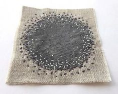 a piece of cloth with silver sequins on it and a black circle in the middle