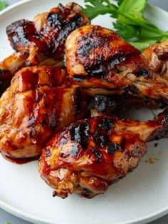 grilled chicken wings on a white plate with parsley