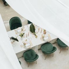 an overhead view of a table with green chairs