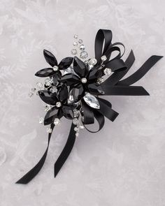 a close up of a black flower on a white background with lots of crystal stones