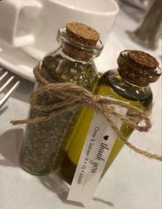 there are two bottles on the table with some herbs in them and one is empty