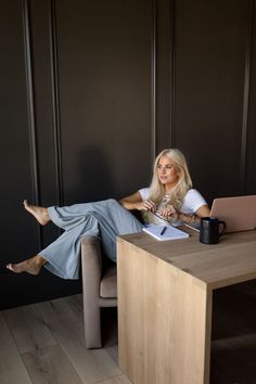 a woman sitting on a chair in front of a desk