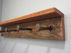 an old wooden coat rack with five hooks on it's sides and three knobs in the middle