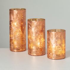 three copper colored candles sitting next to each other