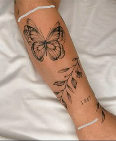 a woman's arm with a butterfly tattoo on the left side of her leg