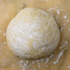 a ball of dough sitting on top of a table covered in powdered sugar and flour