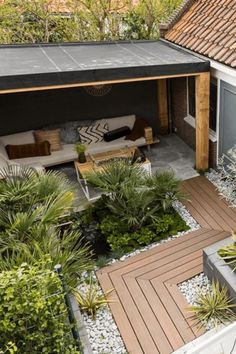 an outdoor living area with plants and rocks