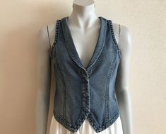 Women's Vest Blue Denim Vest Jeans Vest Fitted Womens Waistcoat Country Western Boho Womens Vest Sleeveless Denim Jacket Suit Collar  Measurements (lying flat): Length(back): 18.5"/ 47 cm Pit to pit: 16.5"/ 42 cm Waist: 15 1/4"/ 39 cm Please check measurements to insure a proper fit. Remember to allow yourself some extra room for movement. You can compare these with something from your closet that fits you well. Please convo me if you need additional measurements. Condition: great Vintage Condit Fitted Light Wash Denim Sleeveless Vest, Light Wash Fitted Sleeveless Denim Vest, Light Wash Fitted Vest For Spring, Blue Denim Vest Top For Spring, Fitted Light Wash Sleeveless Denim Vest, Spring Dark Wash Denim Vest Top, Fitted Casual Denim Blue Vest, Casual Fitted Denim Blue Vest, Fitted Light Wash Denim Vest