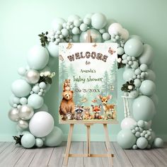 a welcome baby shower sign surrounded by balloons and streamers in the shape of animals