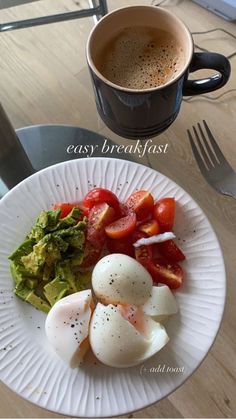 a white plate topped with eggs, tomatoes and avocado next to a cup of coffee