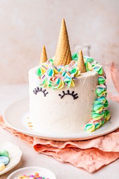 a birthday cake decorated with rainbow sprinkles and an ice cream cone