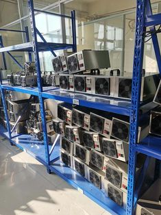 the shelves are full of computers and other electronic equipment in an office building with blue shelving