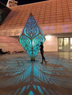 a person standing in front of a large sculpture