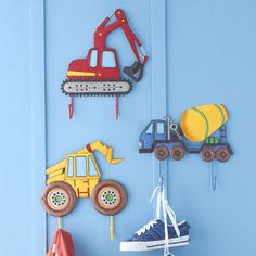 a blue wall with toys hanging from it's sides and an orange toy truck on the other side