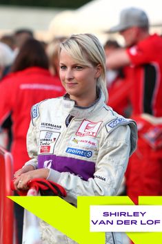 a woman with blonde hair standing in front of a yellow arrow and wearing a white jacket