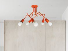 an orange chandelier hanging from the ceiling in a room with wood paneling