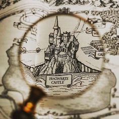 a magnifying glass looking at a hogwart's castle on a map