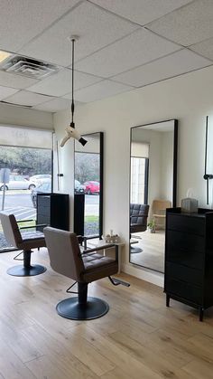 an empty salon room with mirrors and chairs