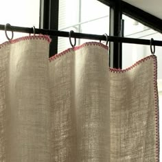 a curtain hanging from a metal rod in front of a window